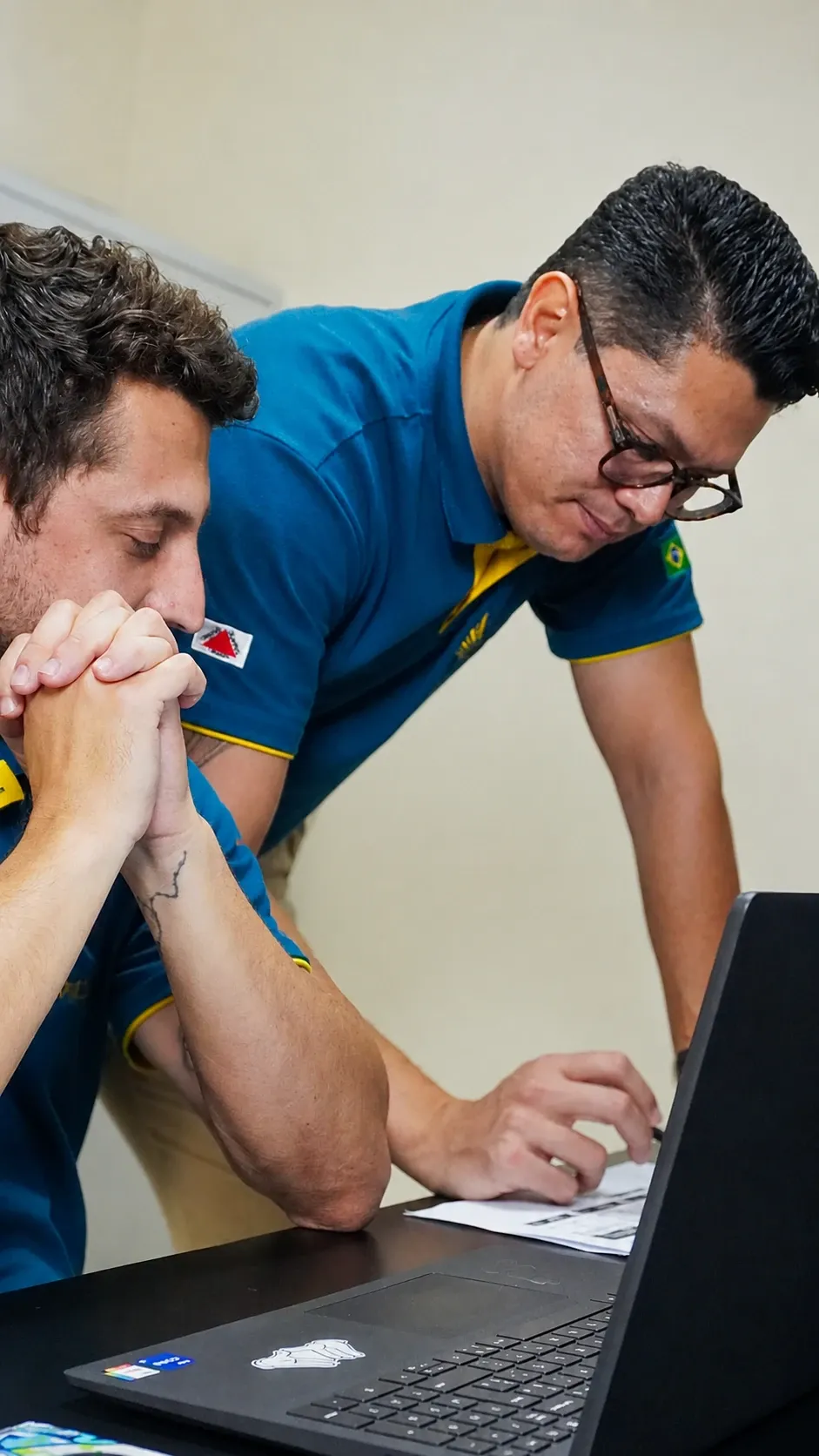 Francklin e integrante da equipe analisando documentos no laptop