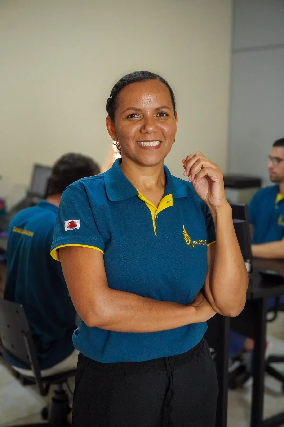 Integrante da equipe da E-volução sorrindo no escritório